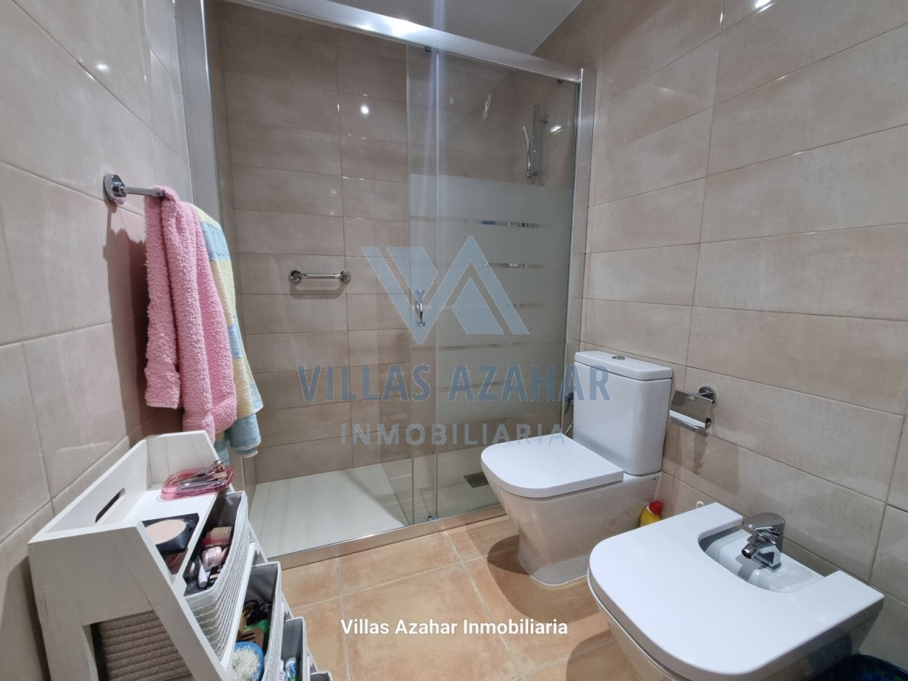 Salle de bain moderne avec confort : douche en verre élégante, meubles de rangement pratiques et équipements sanitaires de haute qualité