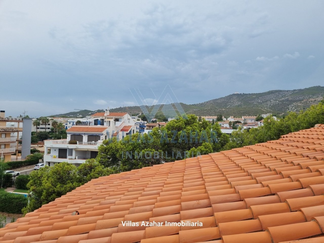 Vue panoramique avec cadre montagne : paysage de toiture méditerranéen avec vue dégagée sur un village côtier